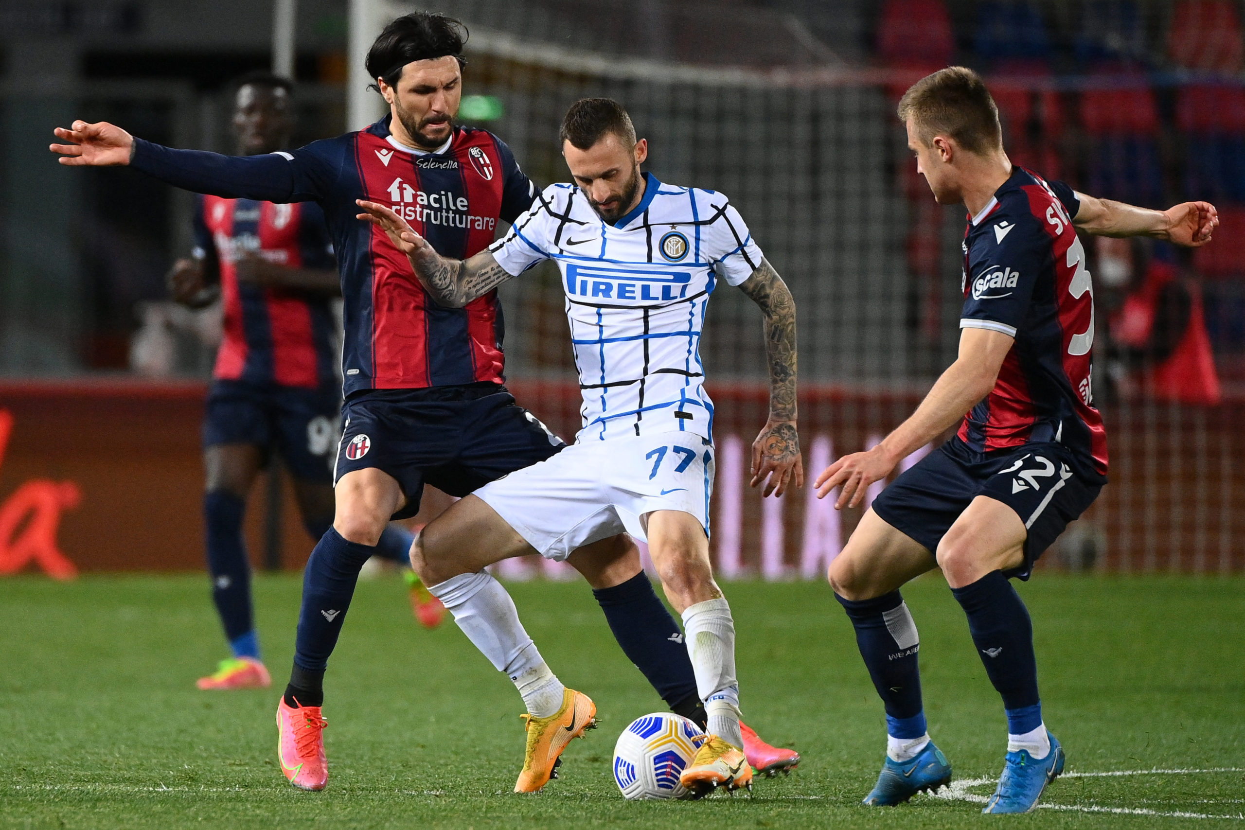 Inter Milan's Croatian midfielder Marcelo Brozovic (C) challenges Bologna's Italian midfielder Roberto Soriano (L)