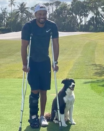 Tiger Woods, on crutches, poses with his pet dog in a photo posted on his Instagram account.