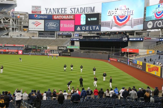 Baseball fans watch as the New York Yankees and Toronto Blue Jays warm up before Opening Day at Yankee Stadium.