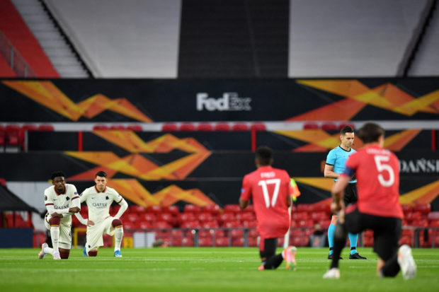 Players 'take a knee' in support of Anti-Racism campaigns ahead of the UEFA Europa League semi-final, first leg football match between Manchester United and Roma at Old Trafford stadium in Manchester, north west England, on April 29, 2021. (Photo by Paul ELLIS / AFP)