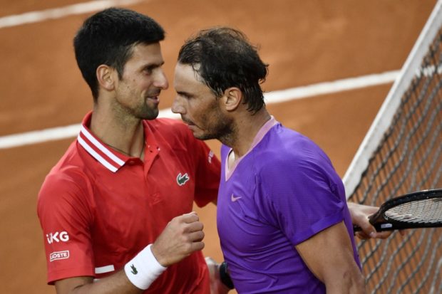 Serbia's Novak Djokovic (L), holding the finalist's trophy and Spain's Rafael Nadal,