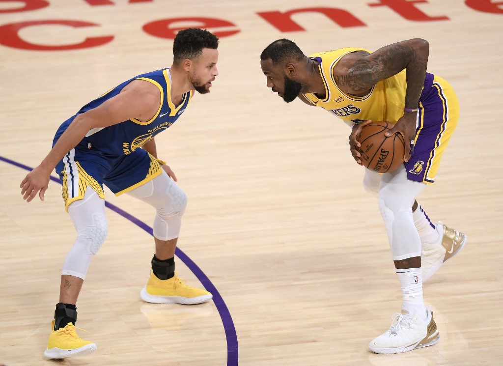 : LeBron James #23 of the Los Angeles Lakers is guarded by Stephen Curry