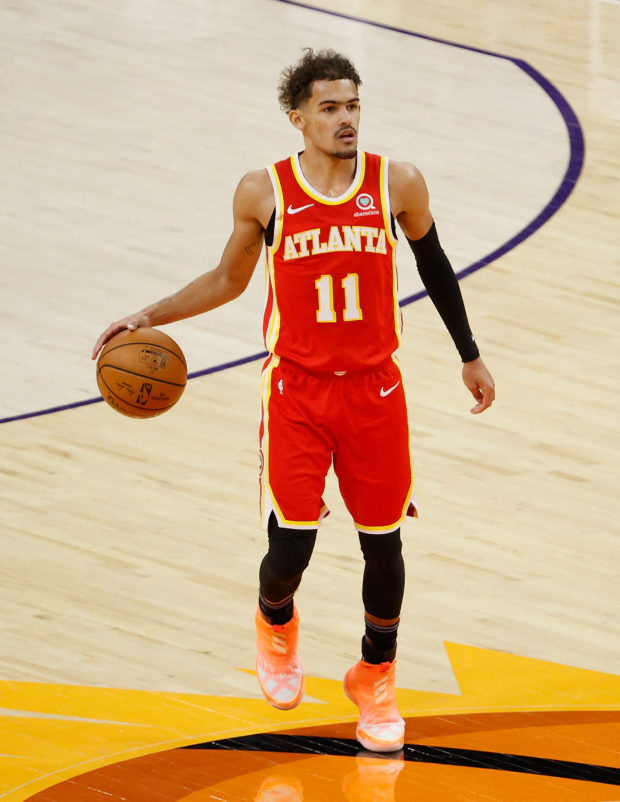 Trae Young #11 of the Atlanta Hawks handles the ball against the Phoenix Suns during the NBA game at Phoenix Suns Arena on March 30, 2021 in Phoenix, Arizona. The Suns defeated the Hawks 117-110. NOTE TO USER: User expressly acknowledges and agrees that, by downloading and or using this photograph, User is consenting to the terms and conditions of the Getty Images License Agreement.   Christian Petersen/Getty Images/AFP (Photo by Christian Petersen / GETTY IMAGES NORTH AMERICA / Getty Images via AFP)