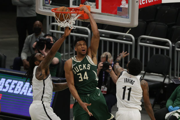 Giannis Antetokounmpo #34 of the Milwaukee Bucks dunks in front of DeAndre Jordan #6 and Kyrie Irving #11 of the Brooklyn Nets during the first half of a game at Fiserv Forum on May 02, 2021 in Milwaukee, Wisconsin. 