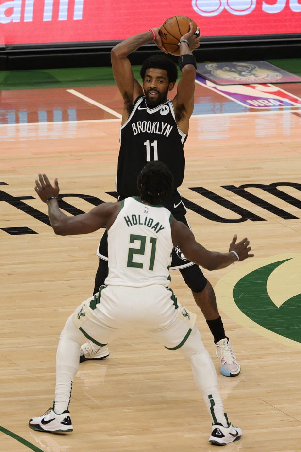 Kyrie Irving #11 of the Brooklyn Nets is defended by Jrue Holiday #21 of the Milwaukee Bucks during the first half of a game at Fiserv Forum on May 04, 2021 in Milwaukee, Wisconsin. NOTE TO USER: User expressly acknowledges and agrees that, by downloading and or using this photograph, User is consenting to the terms and conditions of the Getty Images License Agreement.   Stacy Revere/Getty Images/AFP (Photo by Stacy Revere / GETTY IMAGES NORTH AMERICA / Getty Images via AFP)