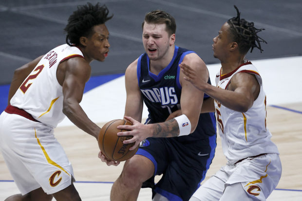 Luka Doncic #77 of the Dallas Mavericks drives to the basket against Isaac Okoro #35 of the Cleveland Cavaliers and Collin Sexton #2 of the Cleveland Cavaliers in the second quarter at American Airlines Center on May 07, 2021 in Dallas, Texas. NOTE TO USER: User expressly acknowledges and agrees that, by downloading and or using this photograph, User is consenting to the terms and conditions of the Getty Images License Agreement.   Tom Pennington/Getty Images/AFP (Photo by TOM PENNINGTON / GETTY IMAGES NORTH AMERICA / Getty Images via AFP)