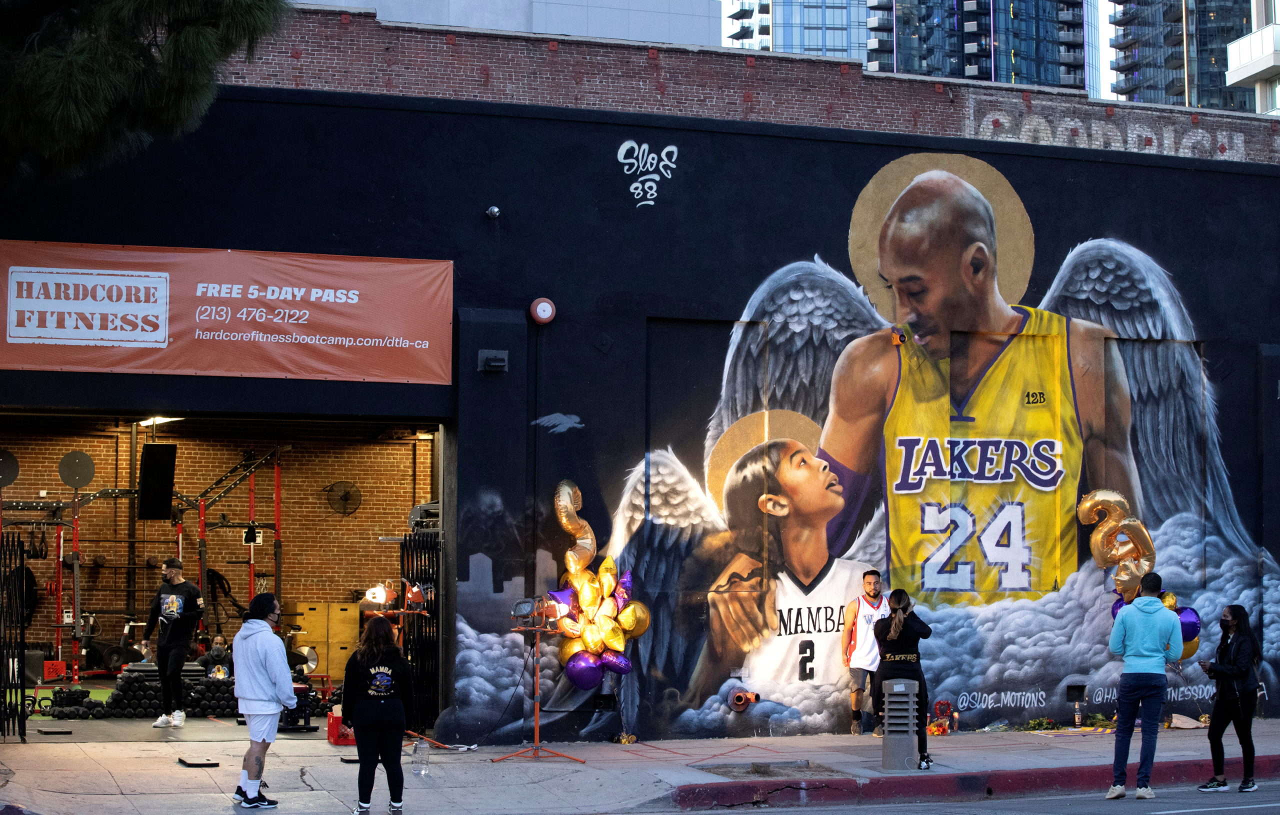 People stop by a mural of late Kobe Bryant, who perished one year ago alongside his daughter and seven others when their helicopter crashed into a hillside, in Los Angeles