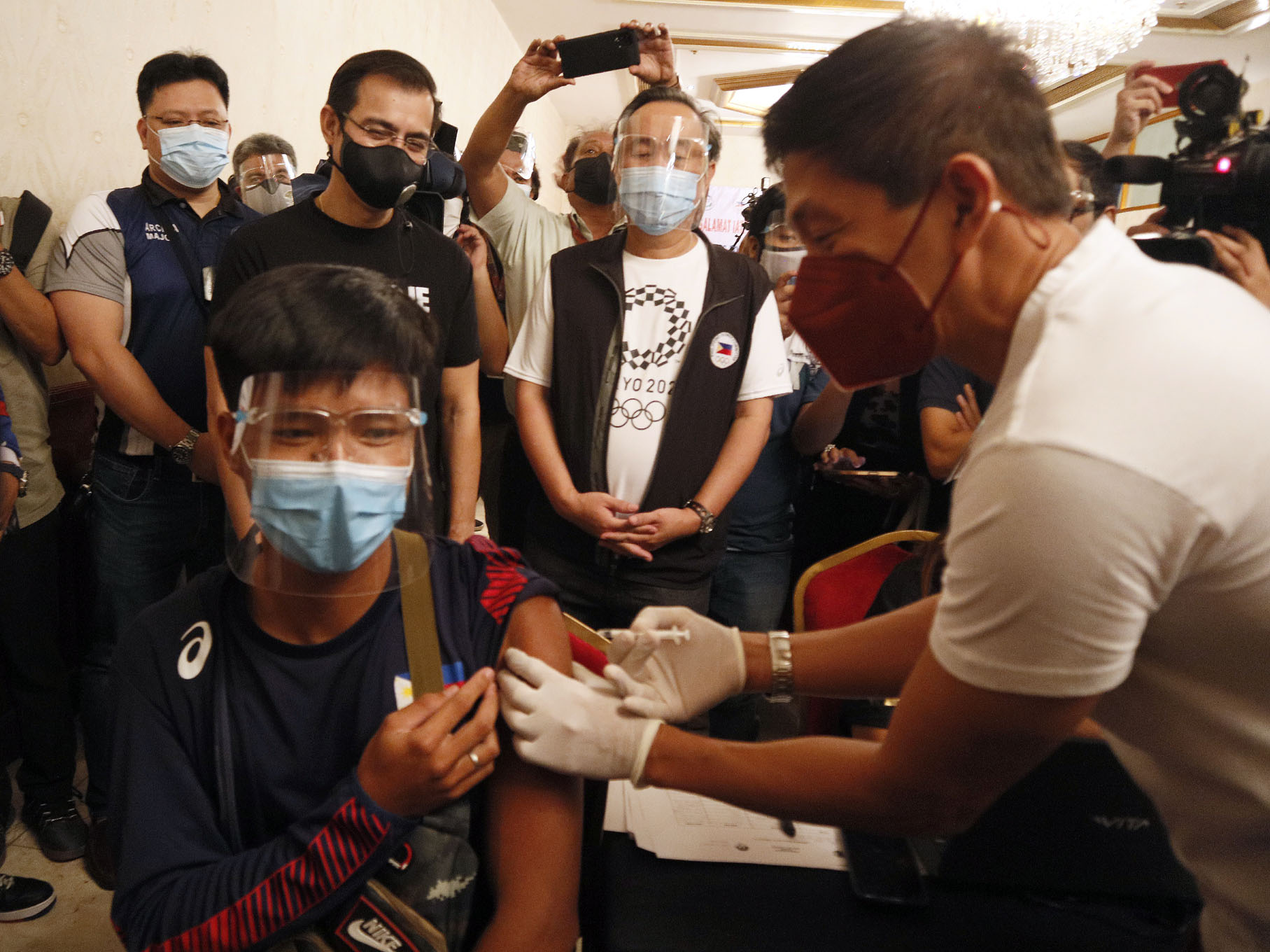 Tokyo Olympics-bound rower Cris Nievarez takes his first dose of the Sinovac vaccine