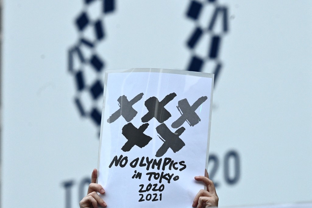An anti-Olympic activist holds a paper of no Olympics in Tokyo 2020 2021 in a protest outside the metropolitan government building, 30 days before the Olympic Games opening ceremonies, in Tokyo on June 23, 2021