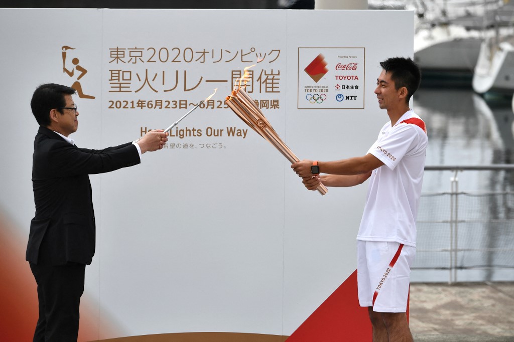 Japanese torch bearer Ajia Arai (R) and Mayor of Ito City Tatsuya Ono (L) hold a departure ceremony prior to the Tokyo 2020 Olympic Games Torch Relay in Ito, Shizuoka prefecture on June 25, 2021.