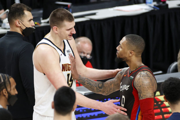 Nikola Jokic #15 of the Denver Nuggets and Damian Lillard #0 of the Portland Trail Blazers shake hands after the Denver Nuggets beat the Portland Trail Blazers 126-115 Round 1, Game 6 of the 2021 NBA Playoffs at Moda Center on June 03, 2021 in Portland, Oregon. NOTE TO USER: User expressly acknowledges and agrees that, by downloading and or using this photograph, User is consenting to the terms and conditions of the Getty Images License Agreement. Steph Chambers/Getty Images/AFP (Photo by Steph Chambers / GETTY IMAGES NORTH AMERICA / Getty Images via AFP)
