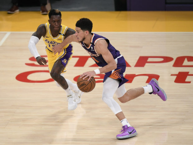 Devin Booker #1 of the Phoenix Suns dribbles in front of Dennis Schroder #17 of the Los Angeles Lakers in the second quarter during game six of the Western Conference first round series at Staples Center on June 03, 2021 in Los Angeles, California. Harry How/Getty Images/AFP NOTE TO USER: User expressly acknowledges and agrees that, by downloading and or using this photograph, User is consenting to the terms and conditions of the Getty Images License Agreement. (Photo by Harry How / GETTY IMAGES NORTH AMERICA / Getty Images via AFP)