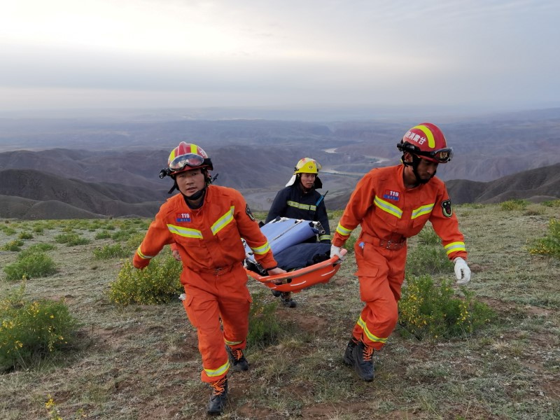 Rescue workers carry a stretcher as they work at the site where extreme cold weather killed participants of an 100-km ultramarathon race