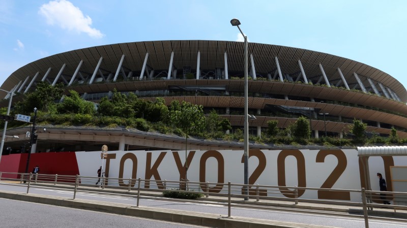 People walk outside the security fence of Olympic Stadium (National Stadium) built for Tokyo Olympic Games,
