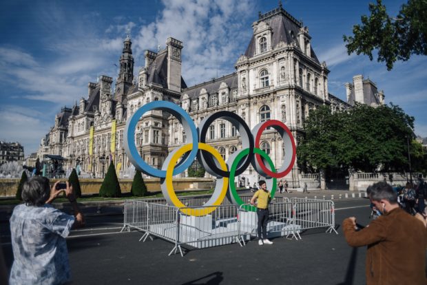 People pose in front of the Olympics rings installed in front of the Paris City Hall during the "Olympics Day" organized by the the "Comite National Olympique et Sportif Francais " (CNOSF) to celebrate the upcoming of the 2024 Paris Olympics Games, in Paris on June 23, 2018. AFP