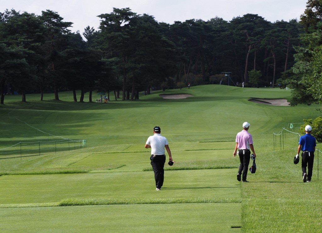 Golfers walk down the first hole fairway during the Japan junior golf championships, a test event ahead of the Tokyo 2020 Olympic Games at the Kasumigaseki country club in Kawagoe on August 14, 2019