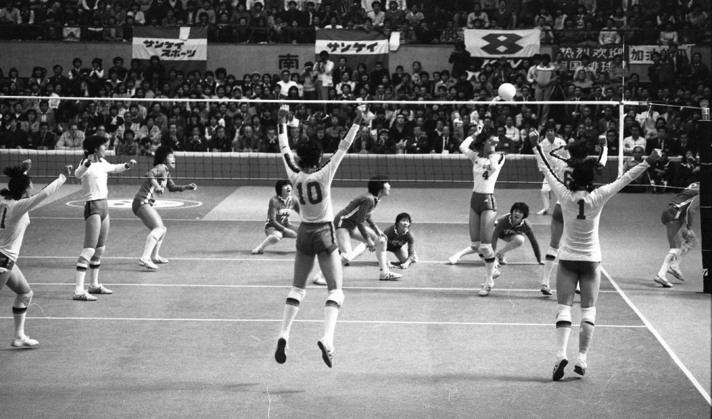 This photo taken on November 16, 1981 shows members of China's volleyball team (in white tops) celebrating their victory over Japan at the end of the final match between China and Japan at the women's volleyball World Cup in Osaka. - On November 16, 1981, millions of people across China crowded around radios and televisions with flickering signals for a women's volleyball match whose significance went far beyond sport. (
