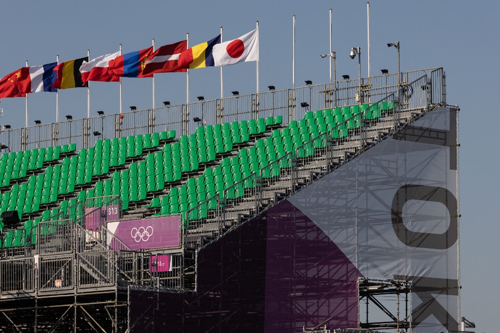 A general view shows flags over empty seats by the court at Aomi Urban Sports Park, the main venue for 3x3 basketball during the Tokyo 2020 Olympic Games, in Tokyo on July 19, 2021