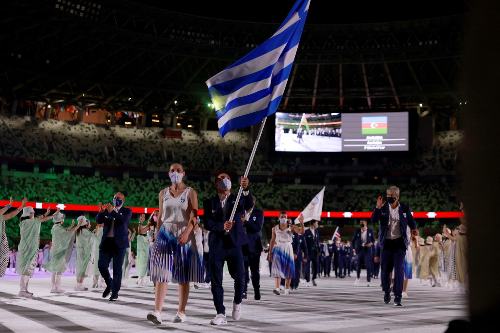 Greece's flag bearers Anna Korakaki (L) and Eleftherios Petrounias (R) parade with members of Greece's delegation during the opening ceremony of the Tokyo 2020 Olympic Games, at the Olympic Stadium, in Tokyo, on July 23, 2021.