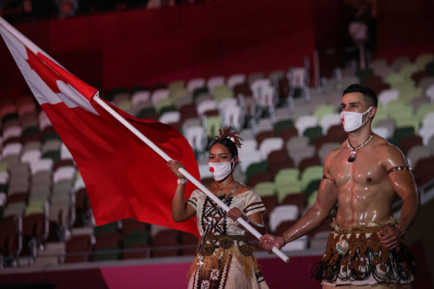 Tonga's flag bearers Malia Paseka (L) and Pita Taufatofua lead the delegation during the Tokyo 2020 Olympic Games opening ceremony's parade of athletes, at the Olympic Stadium in Tokyo on July 23, 2021. 