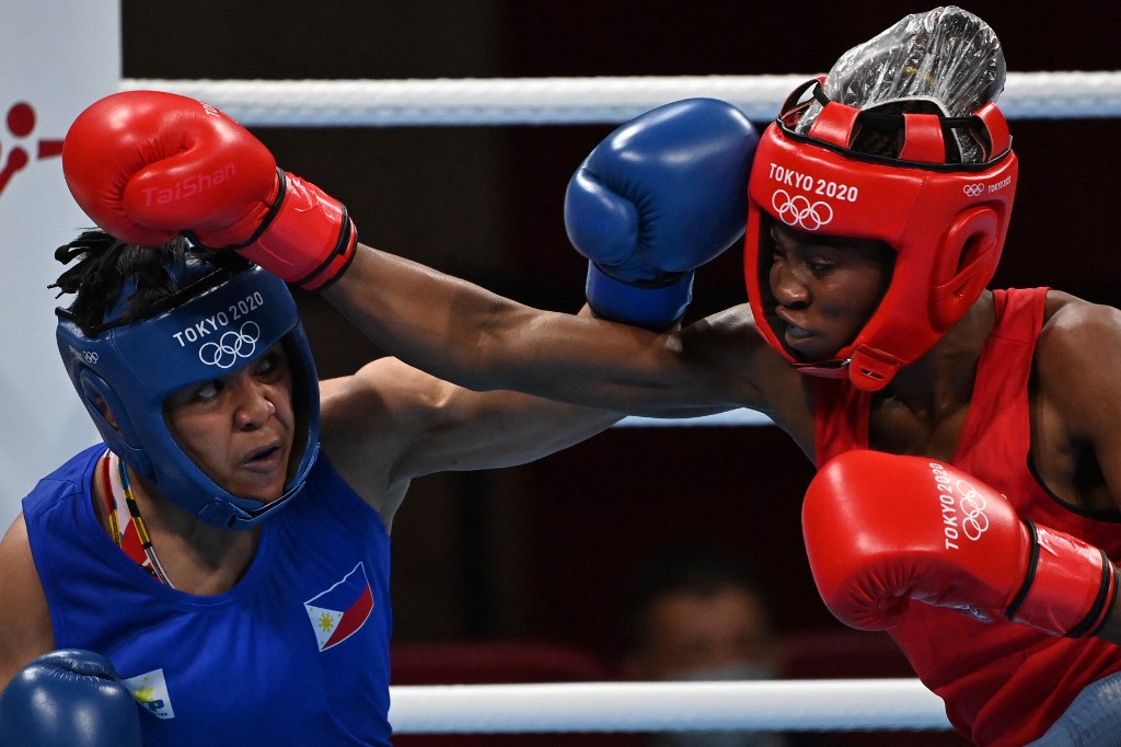 DR Congo's Marcelat Sakobi Matshu (red) and Philippines' Nesthy Petecio fight during their women's feather (54-57kg) preliminaries boxing match during the Tokyo 2020 Olympic Games at the Kokugikan Arena in Tokyo on July 24, 2021. (Photo by Luis ROBAYO / AFP)