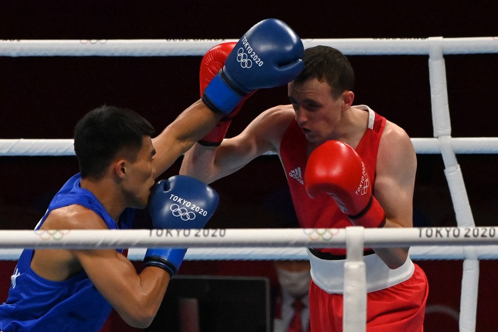 Ireland's Brendan Irvine (red) and Philippines' Carlo Paalam fight during their men's fly (48-52kg) preliminaries boxing match during the Tokyo 2020 Olympic Games at the Kokugikan Arena in Tokyo on July 26, 2021