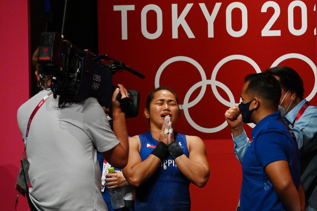 Philippines' Hidilyn Diaz (2nd L) reacts after placing first in the women's 55kg weightlifting competition during the Tokyo 2020 Olympic Games at the Tokyo International Forum in Tokyo on July 26, 2021.