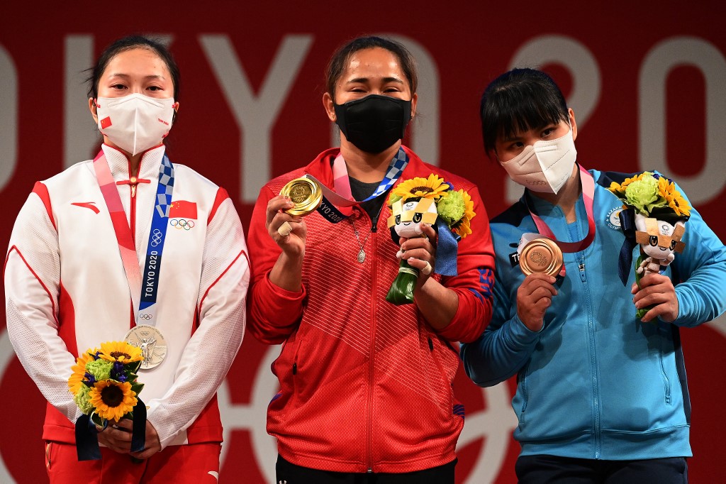 (From L to R) Silver medallist China's Liao Qiuyun , gold medallist Philippines' Hidilyn Diaz and bronze medallist Kazakhstan's Zulfiya Chinshanlo stand on the podium for the victory ceremony of the women's 55kg weightlifting competition during the Tokyo 2020 Olympic Games at the Tokyo International Forum in Tokyo on July 26, 2021.