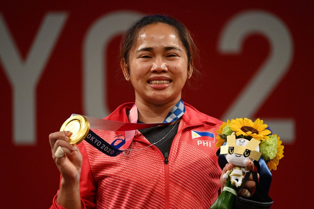 FILE–Gold medallist Philippines' Hidilyn Diaz stand on the podium for the victory ceremony of the women's 55kg weightlifting competition during the Tokyo 2020 Olympic Games at the Tokyo International Forum in Tokyo on July 26, 2021. (Photo by Vincenzo PINTO / AFP)