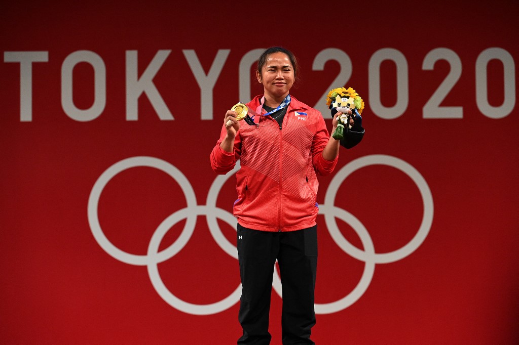 Gold medallist Philippines' Hidilyn Diaz stand on the podium for the victory ceremony of the women's 55kg weightlifting competition during the Tokyo 2020 Olympic Games at the Tokyo International Forum in Tokyo on July 26, 2021.