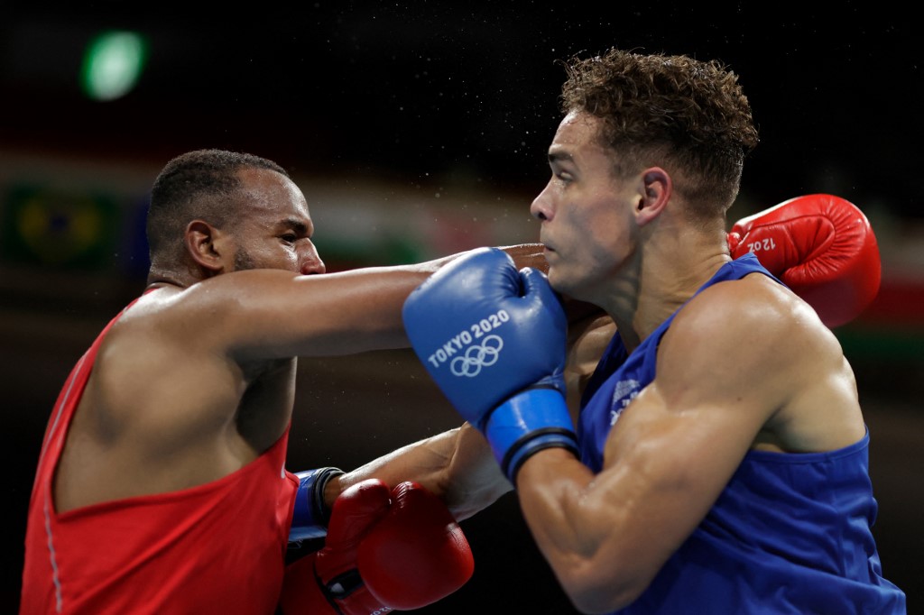 Morocco's Youness Baalla (red) and New Zealand's David Nyika fight during their men's heavy (81-91kg) preliminaries round of 16 boxing match during the Tokyo 2020 Olympic Games at the Kokugikan Arena in Tokyo on July 27, 2021. 