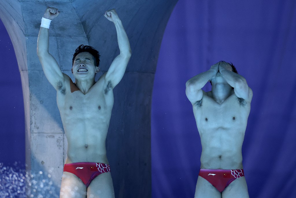 China's Xie Siyi and China's Wang Zongyuan react after winning the men's synchronised 3m springboard diving final event during the Tokyo 2020 Olympic Games at the Tokyo Aquatics Centre in Tokyo on July 28, 2021. 