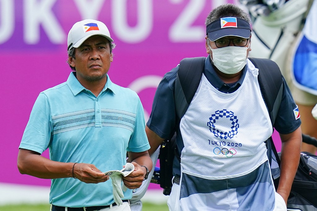 Philippines' Juvic Pagunsan (L) walks with his caddie in round 1 of the mens golf individual stroke play during the Tokyo 2020 Olympic Games at the Kasumigaseki Country Club in Kawagoe on July 29, 2021. 