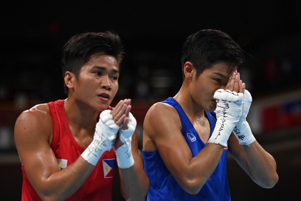 Thailand's Jutamas Jitpong (blue) celebrates after winning against Philippines' Irish Magno after their women's fly (48-51kg) preliminaries round of 16 boxing match during the Tokyo 2020 Olympic Games at the Kokugikan Arena in Tokyo on July 29, 2021. 