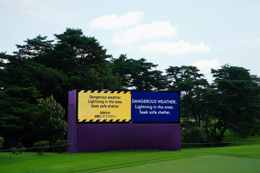 A digital sign board shows a warning of dangerous weather as play is delayed in round 1 of the men’s golf individual stroke play during the Tokyo 2020 Olympic Games at the Kasumigaseki Country Club in Kawagoe on July 29, 2021. 