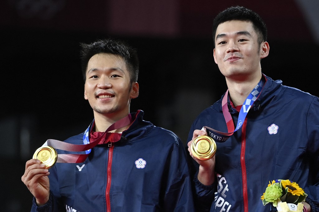 Taiwan's Lee Yang (L) and Taiwan's Wang Chi-lin pose with their men's doubles badminton gold medals at a ceremony during the Tokyo 2020 Olympic Games at the Musashino Forest Sports Plaza in Tokyo on July 31, 2021. 