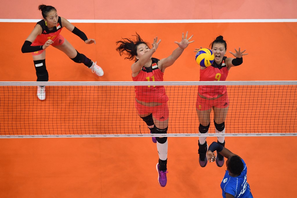 An overview shows China's Xu Yunli (C) and China's Zhang Changning (R) jump to block a shot from Italy's Paola Ogechi Egonu (R) during the women's qualifying volleyball match between China and Italy at the Maracanazinho stadium in Rio de Janeiro on August 8, 2016, during the 2016 Rio Olympics