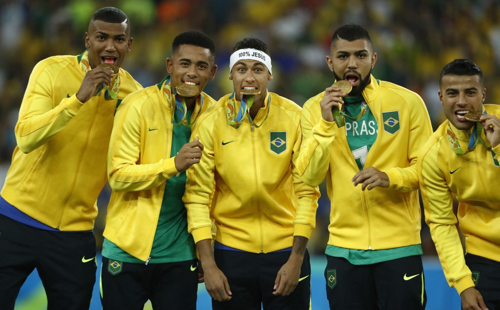 Brazil's players including Neymar (C) celebrate on the podium during the medal presentation following the Rio 2016 Olympic Games men's football gold medal match between Brazil and Germany at the Maracana stadium in Rio de Janeiro on August 20, 2016