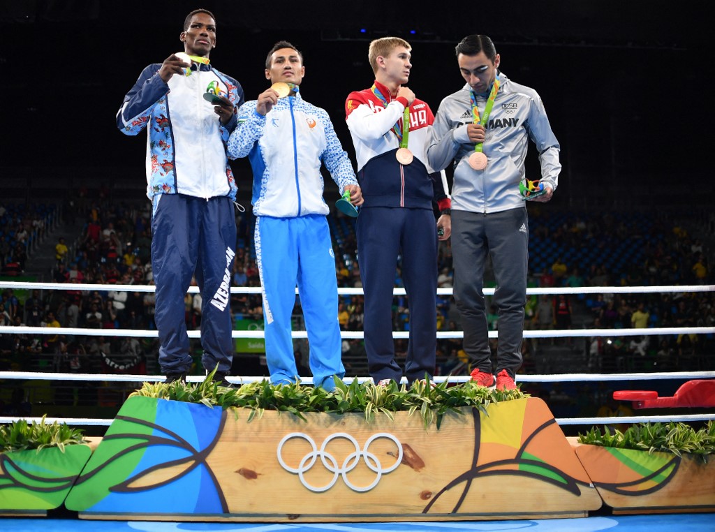 Gold medalist Uzbekistan's Fazliddin Gaibnazarov (2L), silver medalist Azerbaijan's Lorenzo Sotomayor Collazo (L) and bronze medalists Russia's Vitaly Dunaytsev (2R) and Germany's Artem Harutyunyan react during the medal presentation ceremony following the Men's Light Welter (64kg) Final Bout at the Rio 2016 Olympic Games at the Riocentro - Pavilion 6 in Rio de Janeiro on August 21, 2016. 