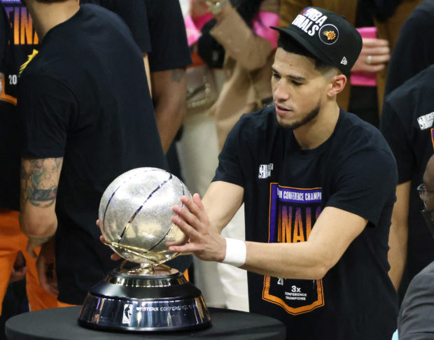 Devin Booker #1 of the Phoenix Suns holds the Western Conference Championship trophy after the Suns defeated the LA Clippers in Game Six of the Western Conference Finals at Staples Center on June 30, 2021 in Los Angeles, California. NOTE TO USER: User expressly acknowledges and agrees that, by downloading and or using this photograph, User is consenting to the terms and conditions of the Getty Images License Agreement.   Harry How/Getty Images/AFP (Photo by Harry How / GETTY IMAGES NORTH AMERICA / Getty Images via AFP)
