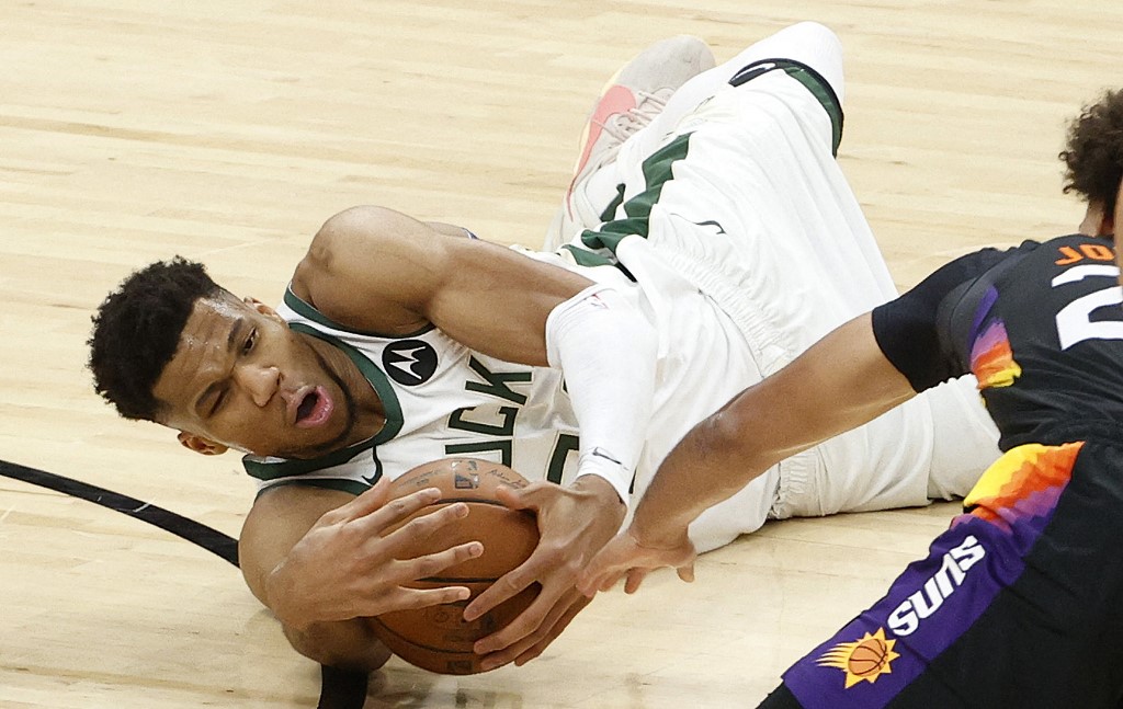 Giannis Antetokounmpo #34 of the Milwaukee Bucks grabs a loose ball against Cameron Johnson #23 of the Phoenix Suns during the second half in Game One of the NBA Finals at Phoenix Suns Arena on July 06, 2021 in Phoenix, Arizona. 
