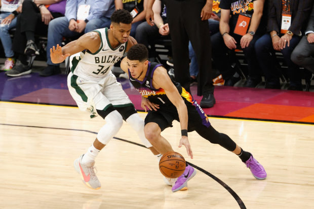 Devin Booker #1 of the Phoenix Suns drives the ball against Giannis Antetokounmpo #34 of the Milwaukee Bucks in game two of the NBA Finals at Phoenix Suns Arena on July 08, 2021 in Phoenix, Arizona. The Suns defeated the Bucks 118-108. 