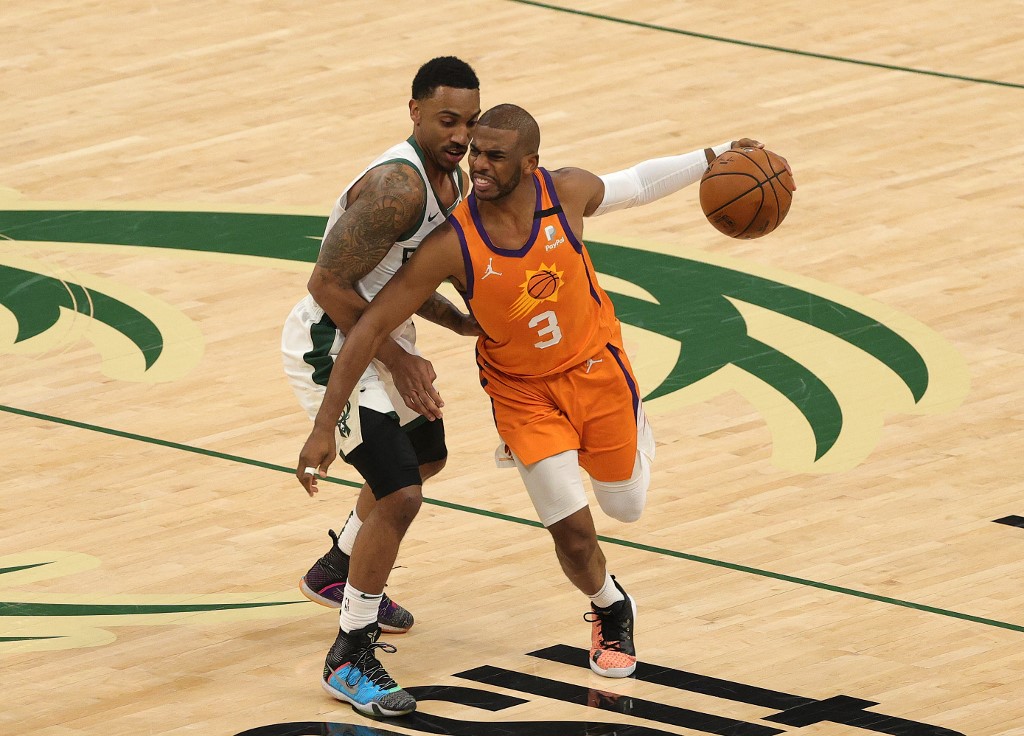 Chris Paul #3 of the Phoenix Suns drives past Jeff Teague #5 of the Milwaukee Bucks during the first half in Game Four of the NBA Finals at Fiserv Forum on July 14, 2021 in Milwaukee, Wisconsin