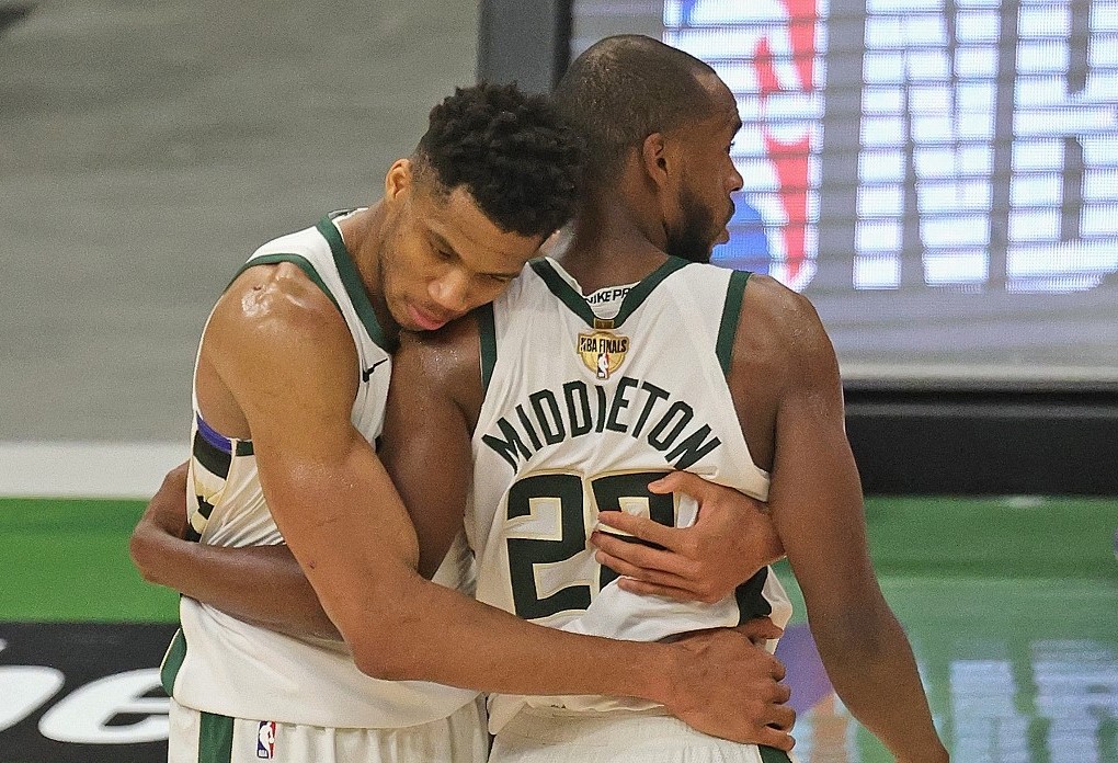 Giannis Antetokounmpo #34 of the Milwaukee Bucks hugs Khris Middleton #22 near the end of the game against the Phoenix Suns at Fiserv Forum on July 14, 2021 in Milwaukee, Wisconsin. The Bucks defeated the Suns 109-103