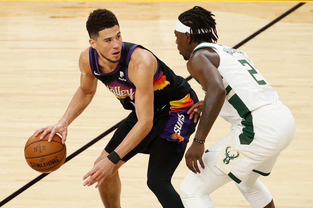 Devin Booker #1 of the Phoenix Suns handles the ball against Jrue Holiday #21 of the Milwaukee Bucks in the second half of game five of the NBA Finals at Footprint Center on July 17, 2021 in Phoenix, Arizona. 