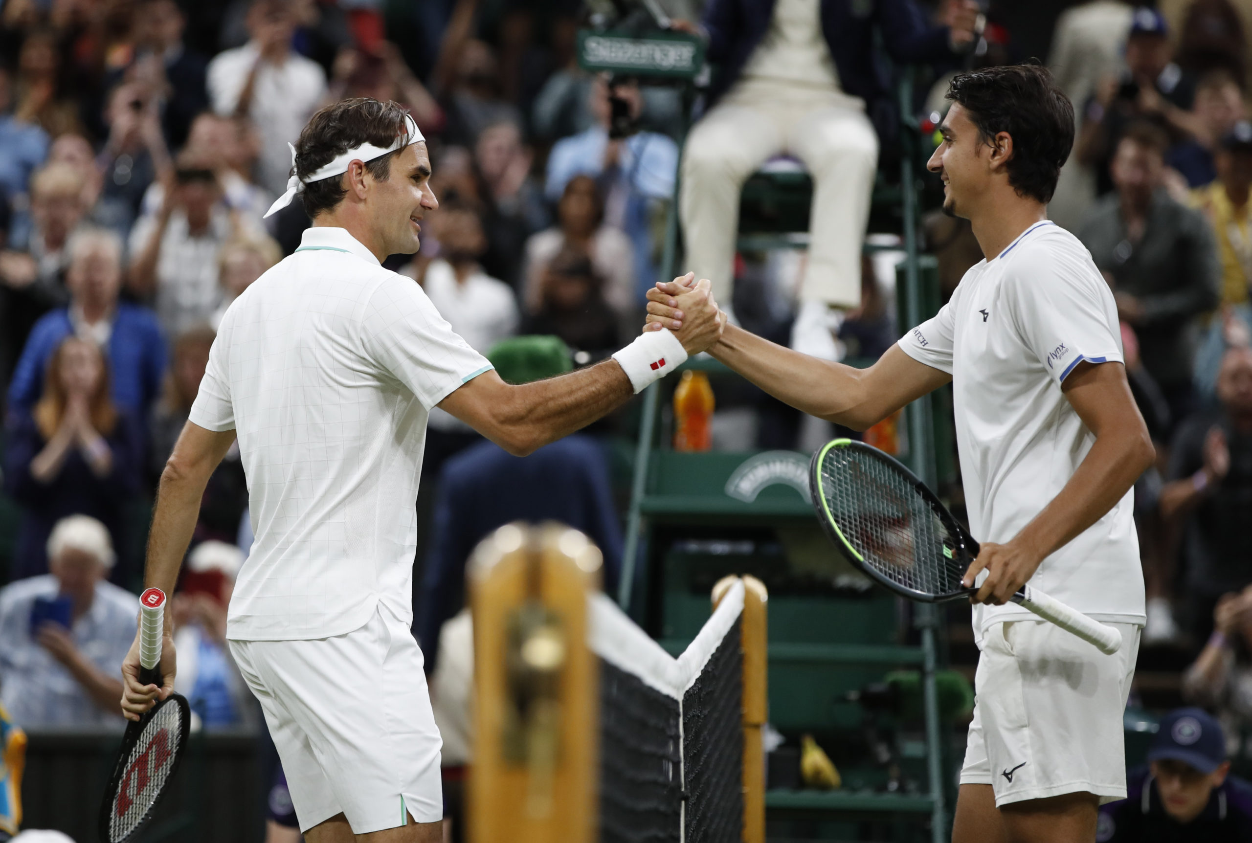 Switzerland's Roger Federer shakes hands with  Italy's Lorenzo Sonego after winning their fourth round match