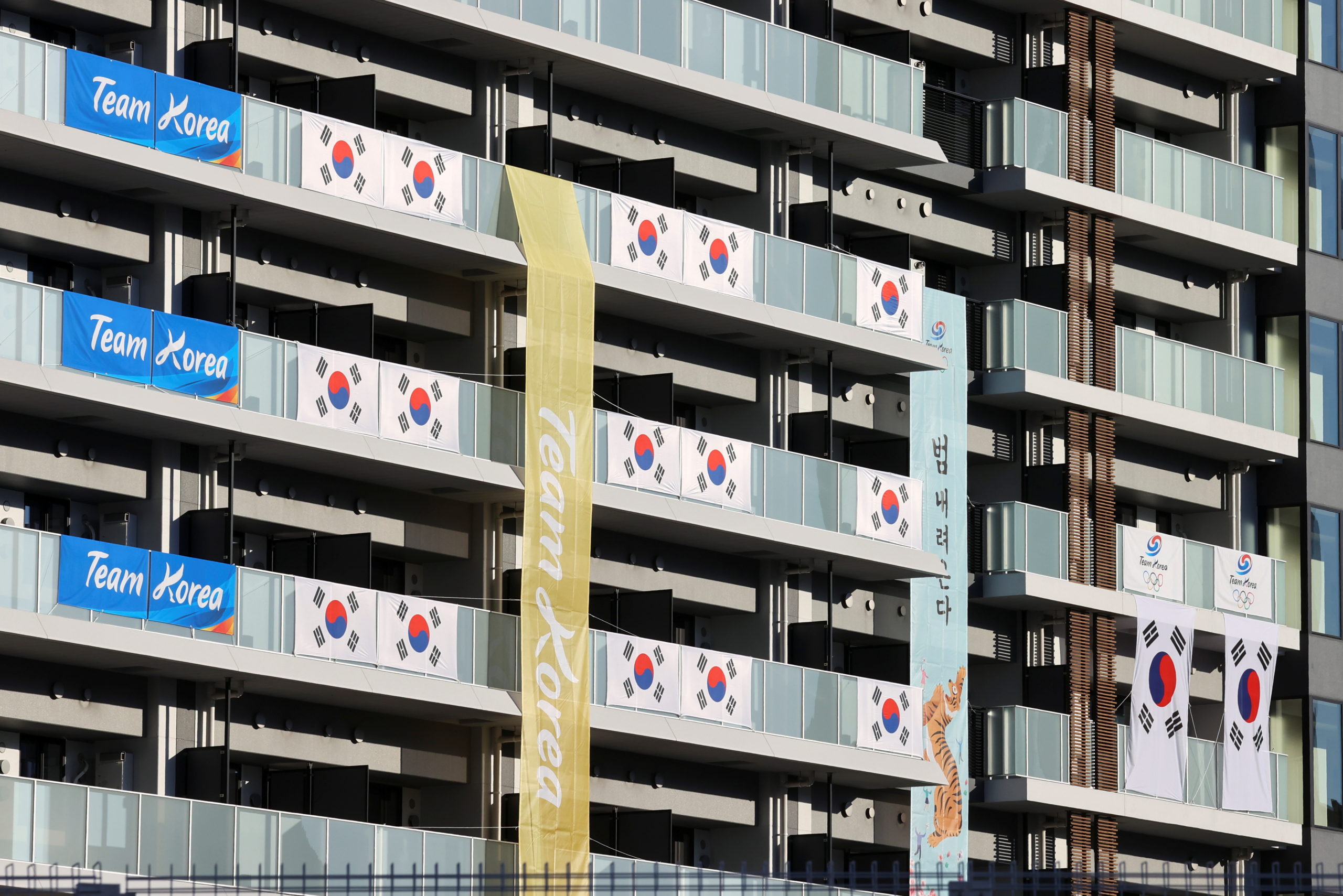 South Korean Flags and signs hang on the appartment building hosting Olympics participants, at the Athletes Village, where a person has tested positive for COVID-19, ahead of Tokyo 2020 Olympic Games in Tokyo, Japan July 17,  2021.