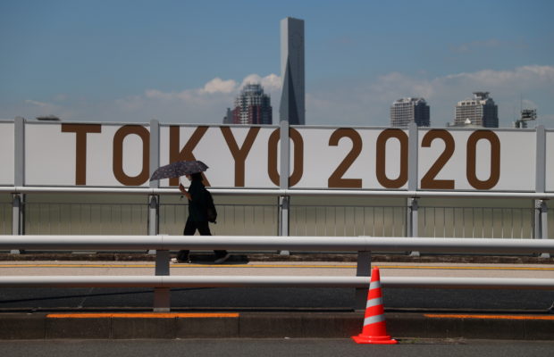 Tokyo 2020 Olympics Preview - Tokyo, Japan - July 19, 2021 A woman shelters from the sun under an umbrella as she walks past Olympics 