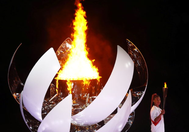 Tokyo 2020 Olympics - The Tokyo 2020 Olympics Opening Ceremony - Olympic Stadium, Tokyo, Japan - July 23, 2021. Naomi Osaka of Japan holds the Olympic torch after lighting the Olympic cauldron at the opening ceremony REUTERS/Mike Blake