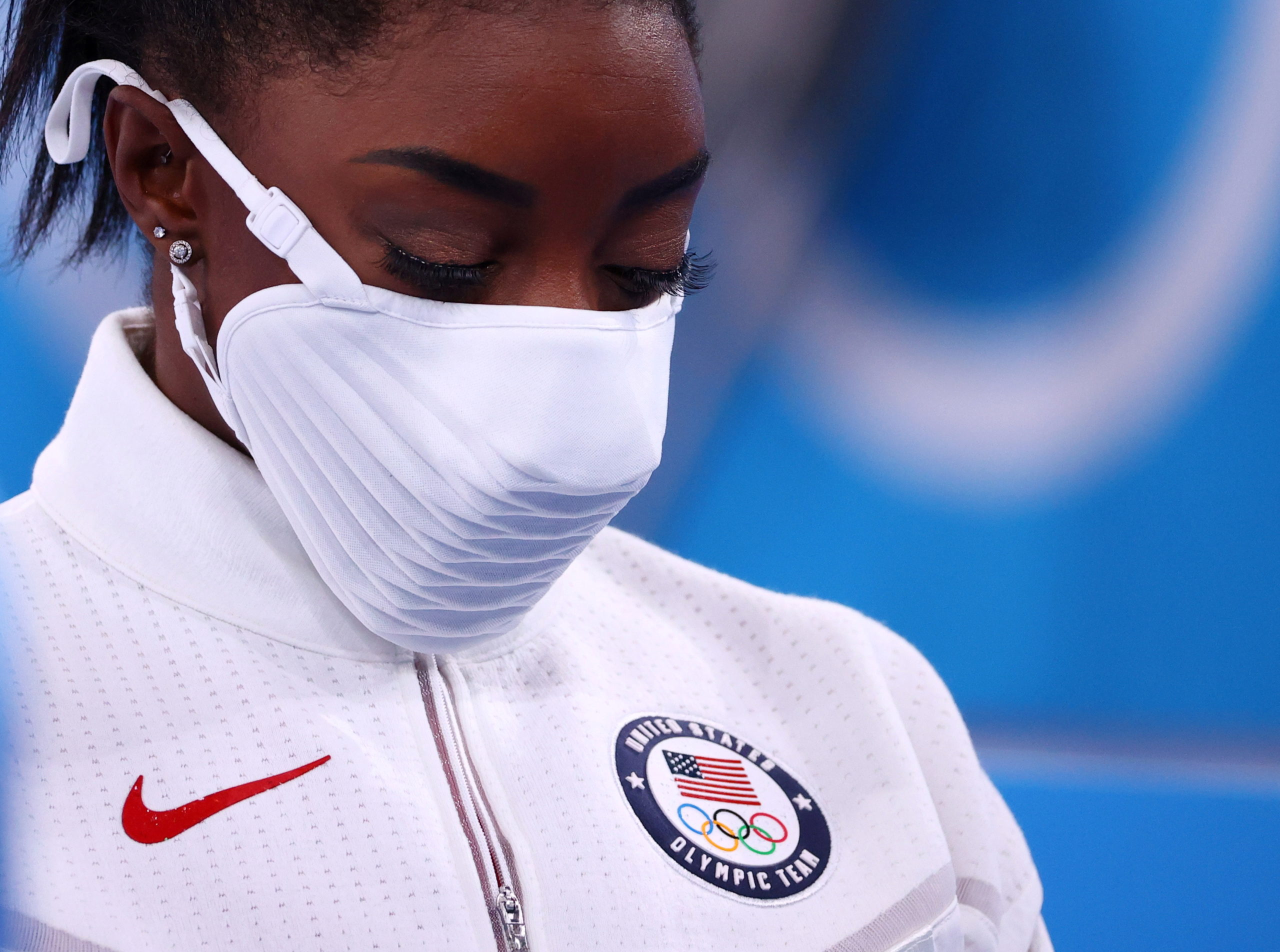 Silver medallist Simone Biles of the United States wearing a protective face mask looks down. 